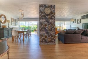 Une grande pièce partagée en deux par un mur décorer d'un papier peint