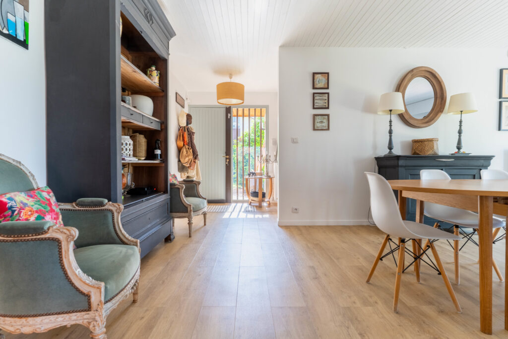 Une photo de l'entrée de la maison avec un porte-manteau, une grande bibliothèque
