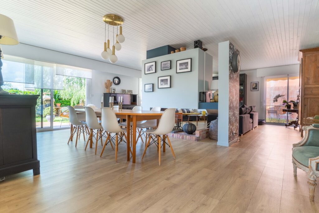 Une photo d'un grand salon avec un mur bleu et des cadres dessus pour décorer