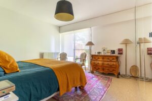 Photo d'une chambre avec un grand lit qui donne sur une baie vitrée