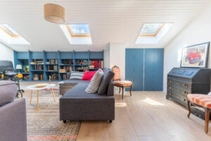 Une photo prise d'un salon avec un canapé bleu de profil