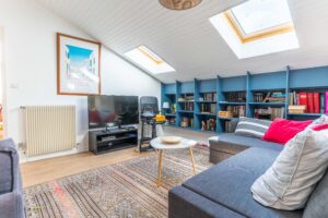 Une photo d'un espace salon avec télévision et un canapé bleu