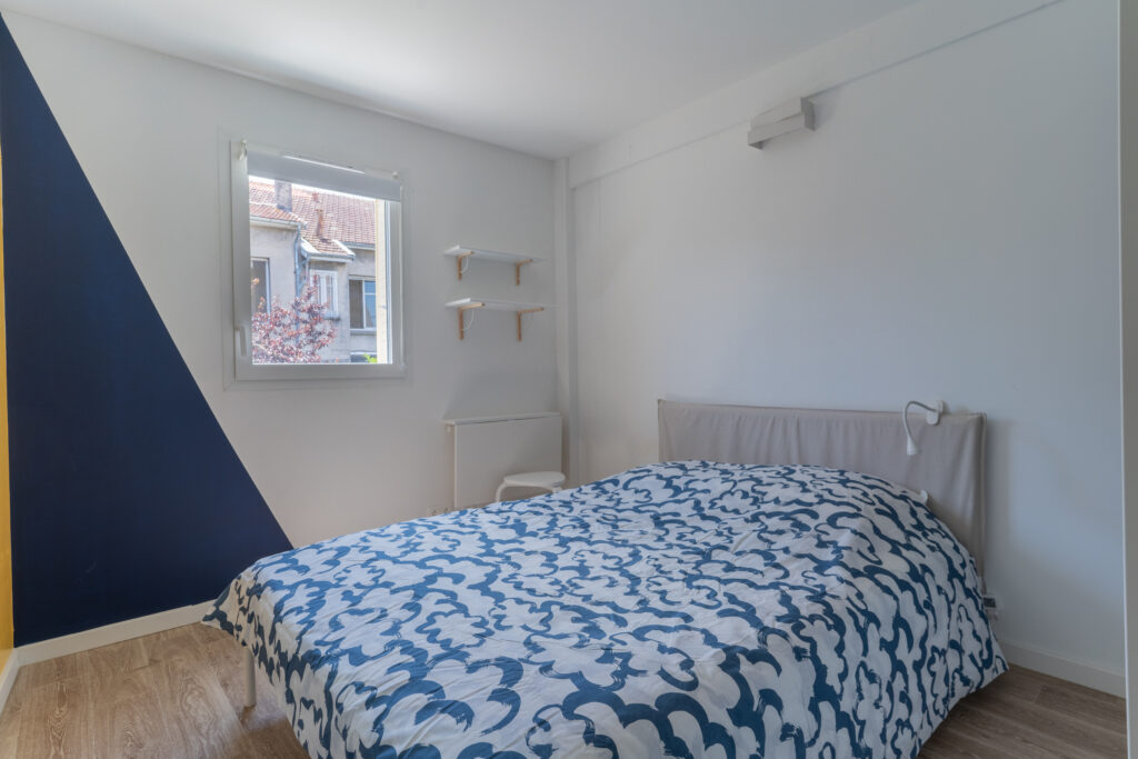 Chambre blanche et bleue avec un lit double